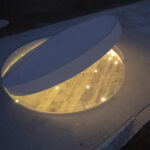 An aluminum-clad disc creates a dramatic entrance portal on the rooftop.