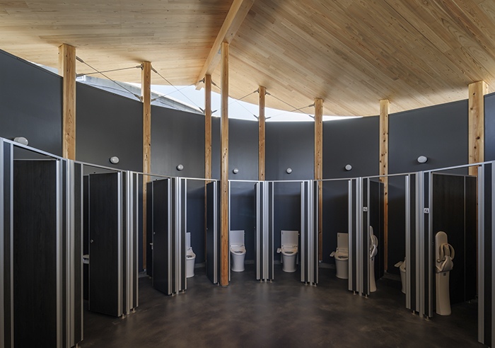 The timber restroom facility continues the project's sustainable design approach. Designed by KOMPAS