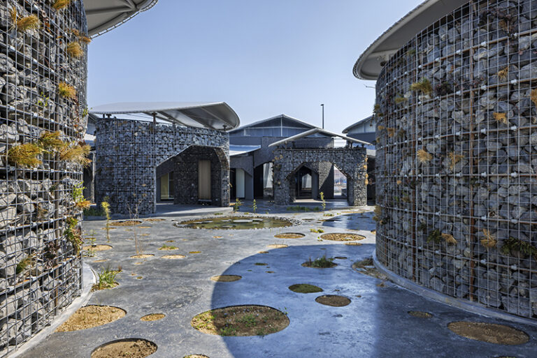 Gabion walls constructed from recycled materials integrate the architecture into the surrounding landscape.