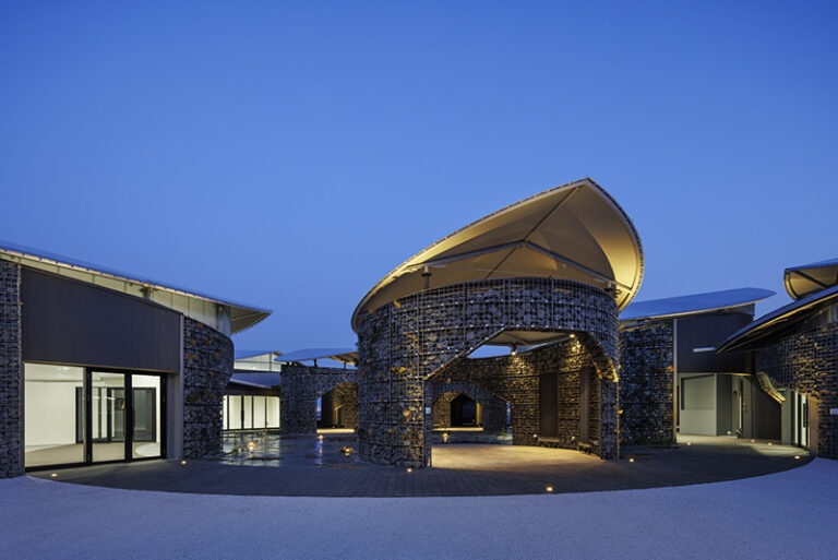 A continuous ring pathway connects circular exhibition units, creating seamless circulation throughout the space. Designed by KOMPAS.