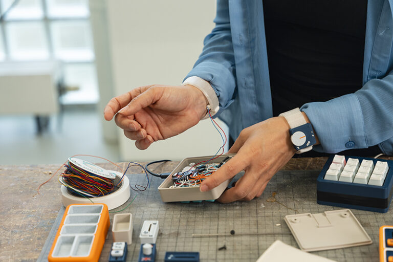 Galli demonstrates OnCue's internal circuitry and wiring system that connects the keyboard to the haptic wearable device.