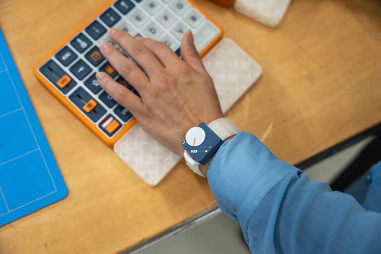 The OnCue wearable provides increasing vibration feedback when a finger remains on a key too long.