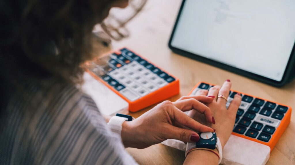 OnCue's vibrant orange base and elevated keycaps create a distinctive therapeutic tool that transforms typing into an accessible activity for Parkinson's patients.