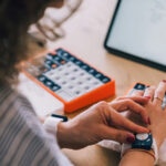 OnCue's vibrant orange base and elevated keycaps create a distinctive therapeutic tool that transforms typing into an accessible activity for Parkinson's patients.