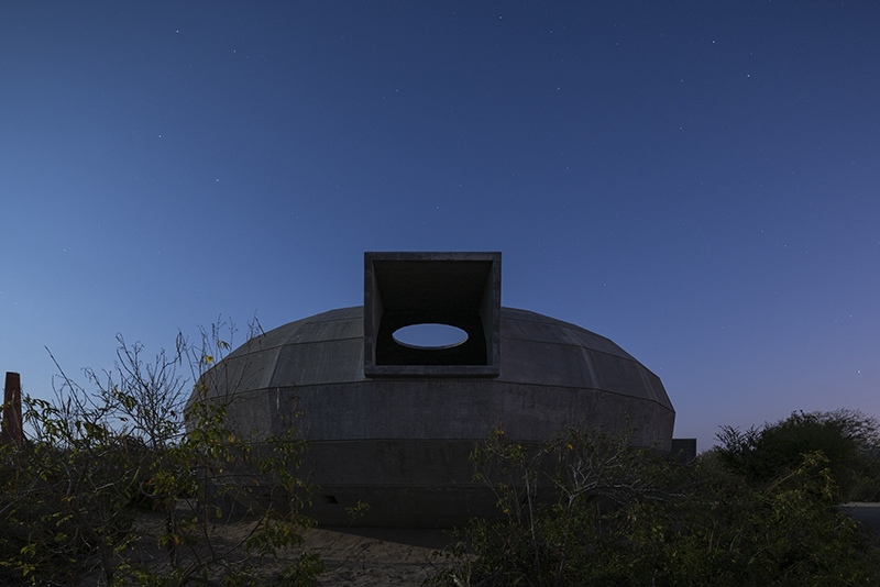 The Mushroom Pavilion at night, oculus frame silhouetted against a star-filled sky