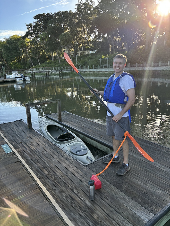 Chris Wilson standing on a dock in the South Carolina Lowcountry with a kayak and paddle