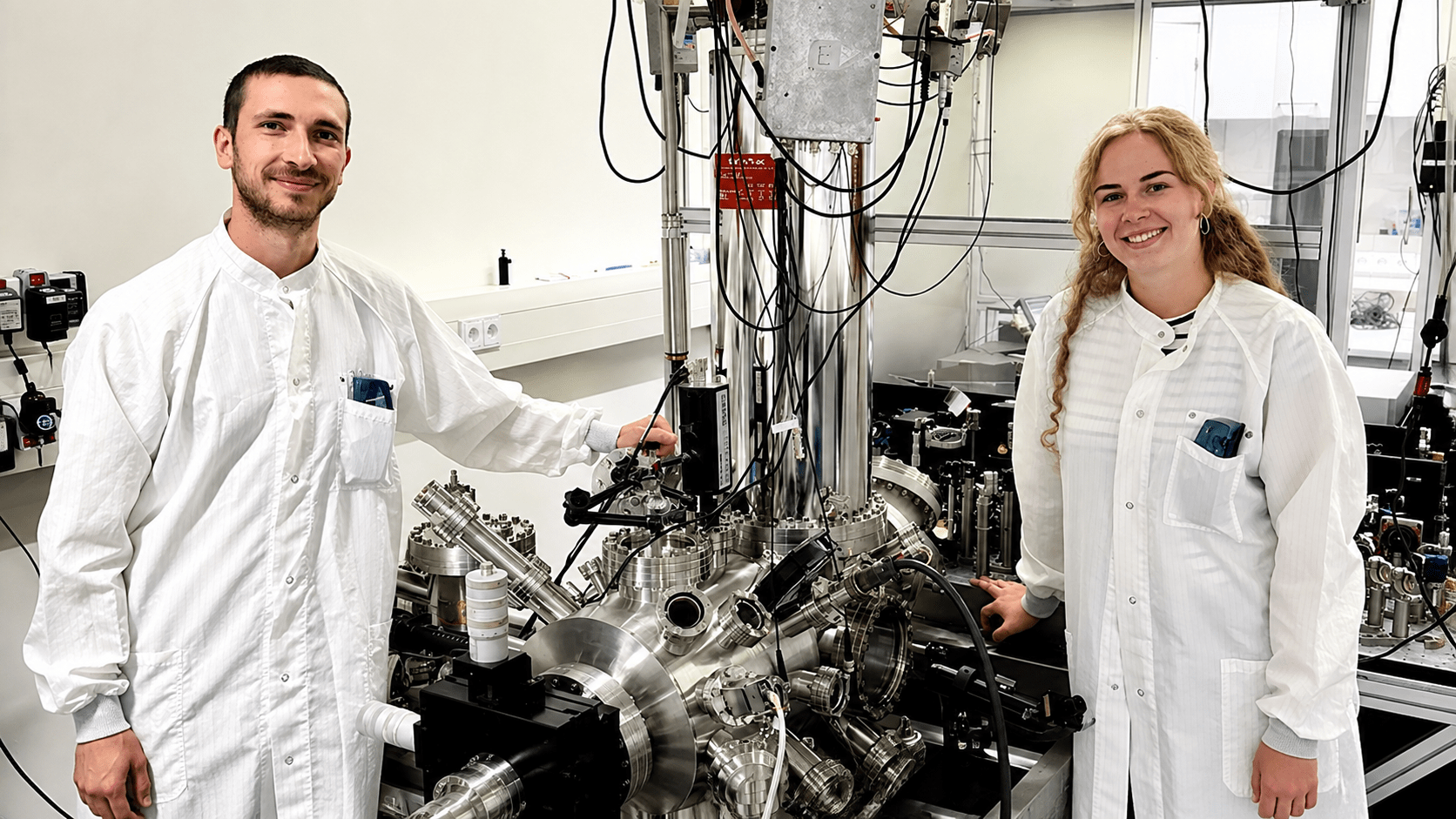 Raffael Spachtholz and Katharina Glöckl beside the scanning tunneling microscope setup used in the experiment