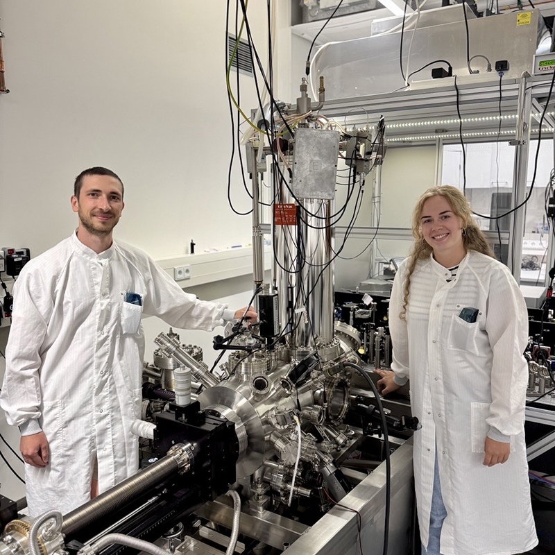 Raffael Spachtholz and Katharina Glöckl beside the scanning tunneling microscope setup used in the experiment