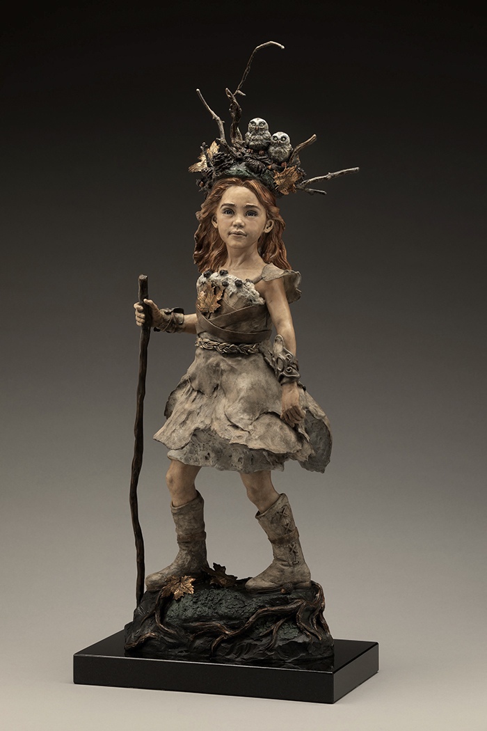 Brave. A girl with a walking stick and a crown of branches where two owls nest, bronze.