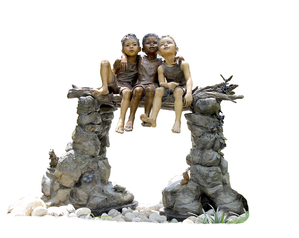Bridge of Brotherhood. Three children sit arm in arm on a log bridge between stone pillars, bronze.