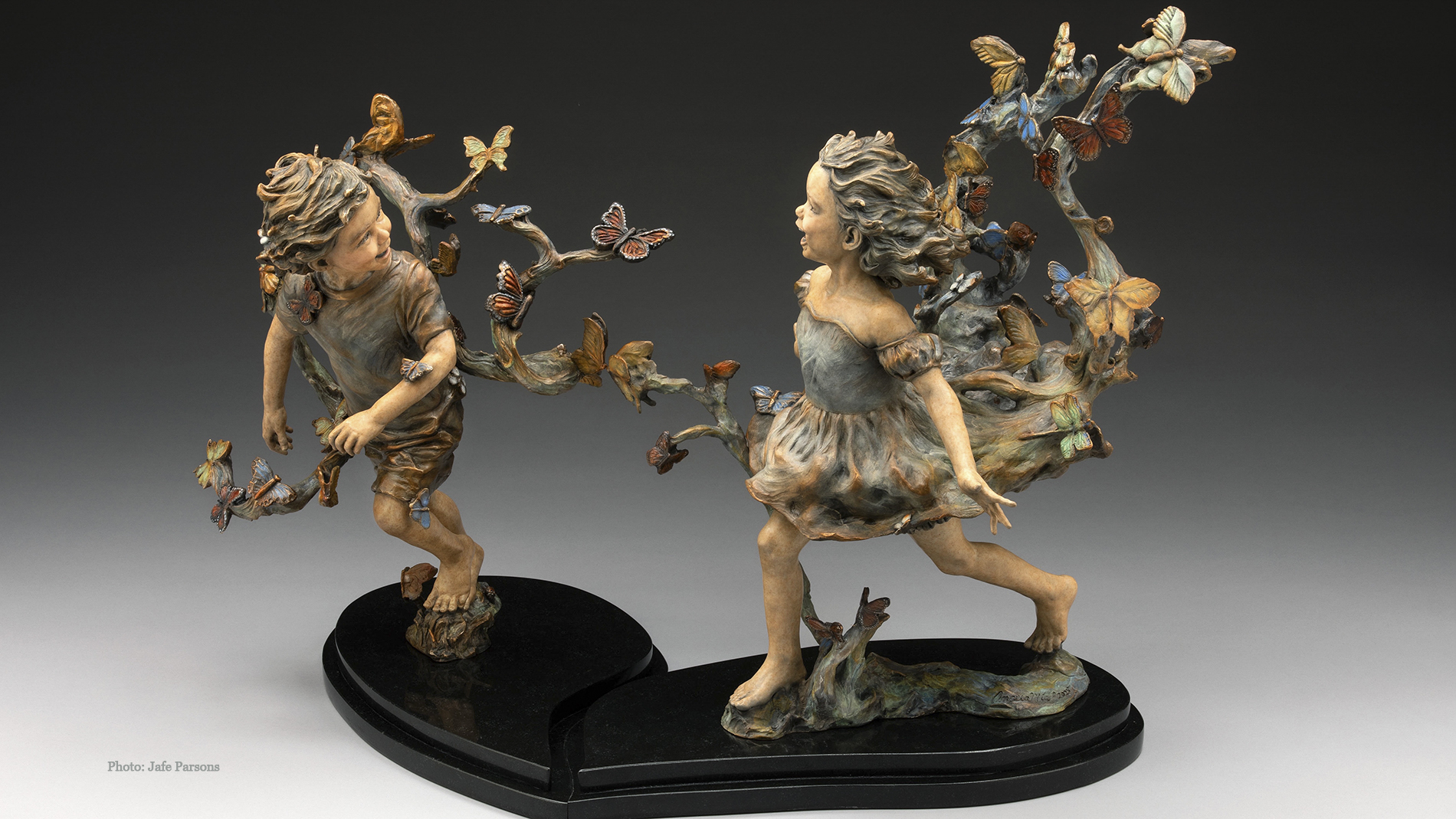 Where Butterflies Lead. Two children run laughing through a swirl of butterflies, bronze