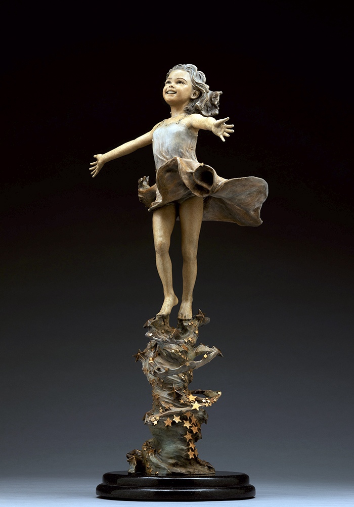 She Moves the Stars. A girl dancing on a swirl of stars, arms flung wide, bronze.