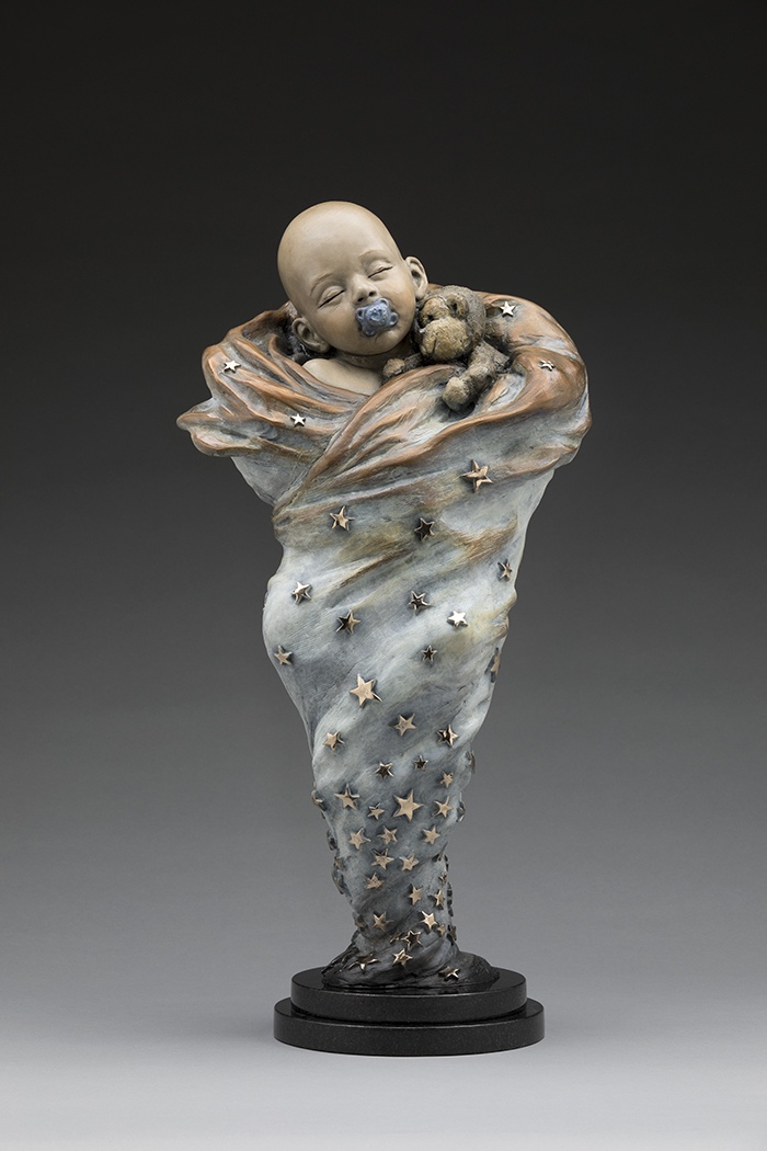 Swaddled Star. A sleeping baby wrapped in a star-covered blanket, bronze.
