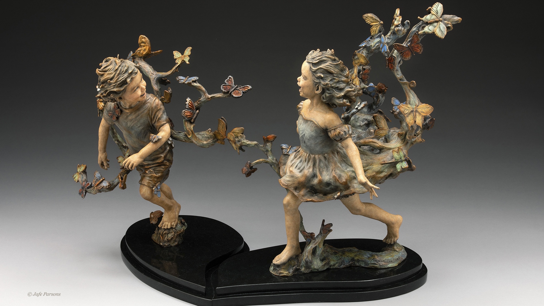 Where Butterflies Lead. Two children run laughing through a swirl of butterflies, bronze