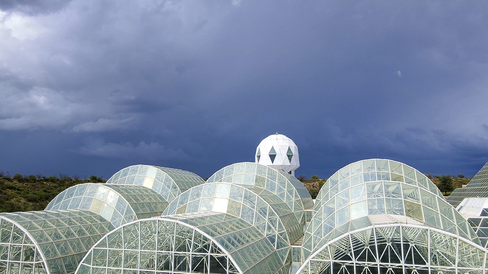 The glass vaults of Biosphere 2 beneath a gathering storm